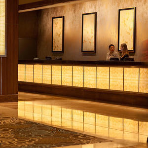 Registration desk and column accents in backlit ViviStone Honey Onyx