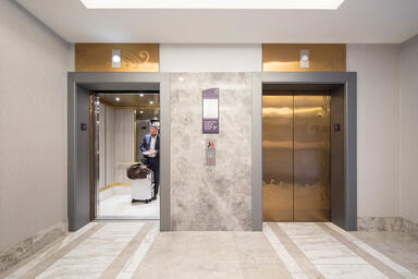 Elevator doors shown in Fused Bronze with Satin finish and custom Eco-Etch 