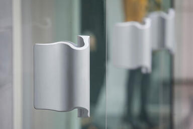 Wave Door Pulls shown in Clear Matte Aluminum at Bebe, Vancouver, BC, Canada