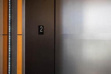 Elevator doors shown in Fused Nickel Silver with Linen finish