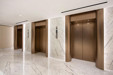 Elevator doors in Fused Nickel Bronze with Seastone finish; elevator jambs in Fu