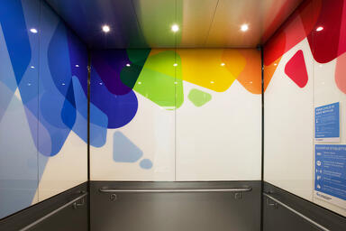 Elevator interior panels with ViviSpectra Spectrum glass in Reflect