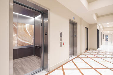 LEVELe-106 Elevator Interior with panels in ViviStone Cream Onyx glass with Pear