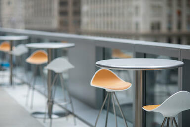 Column Tables in bar-height configuration with 30&rdquo; round table tops in Stainless
