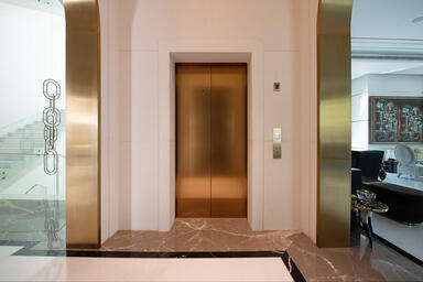 Elevator Doors, transom, and door jambs in Fused Bronze with Linen finish