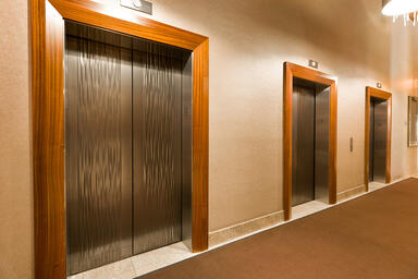 Elevator doors shown in Fused Nickel Silver with Seastone finish and Kalahari pa