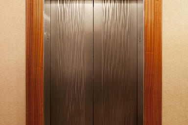 Elevator doors shown in Fused Nickel Silver with Seastone finish and Kalahari