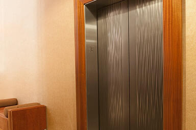 Elevator doors shown in Fused Nickel Silver with Seastone finish and Kalahari
