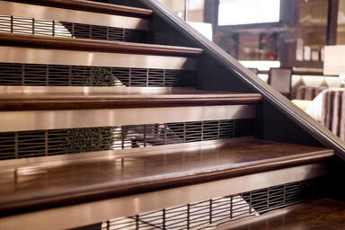 Stair risers in Fused Graphite with Satin finish and custom Kente perforation