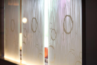 Partition wall shown in ViviGraphix Gradiance glass with custom Switchgrass 