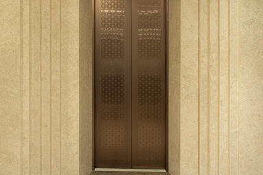 Elevator doors shown in Fused Nickel Bronze with Seastone finish
