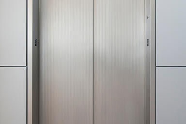 Stainless Steel Elevator Doors in Seastone finish with Dallas Impression pattern